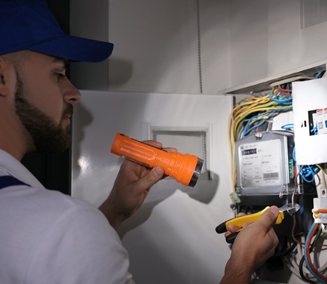 Emergency electrician inspecting electrical cables.